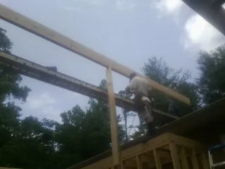 Carpenter setting a ridge beam over a new addition frame — Ice Dam Removal by Roofing Brothers in Shartlesville