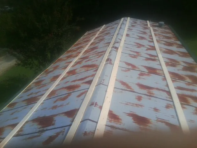 Rusted metal roof panels with new wood purlins before replacement — Storm Damage Roof Repair in Shartlesville by Roofing Brothers