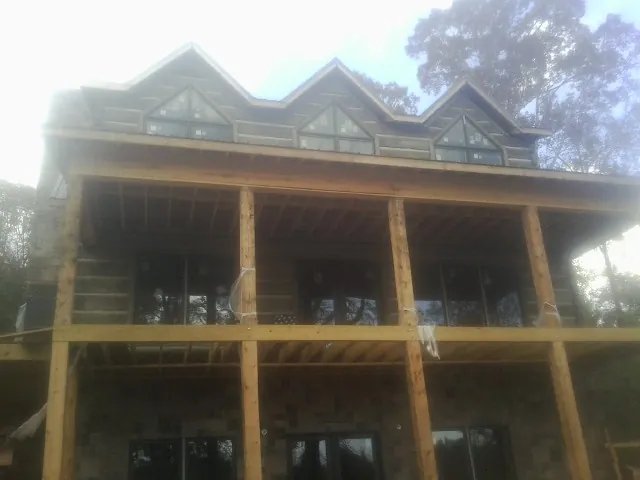 Dormers and porch framing on a large log home under construction — Roof Coating work by our crew in Shartlesville