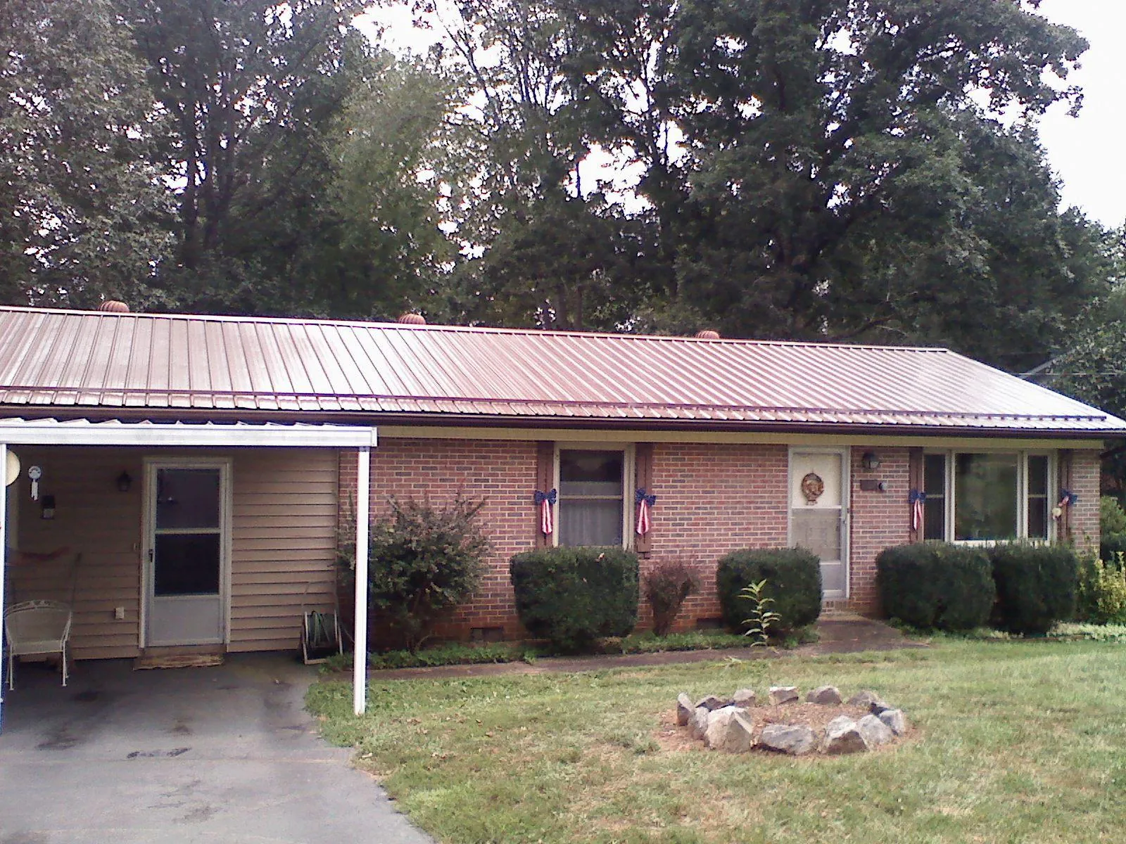 Bronze metal roof and carport on a brick ranch home — Roof Repair work by our crew in Shartlesville